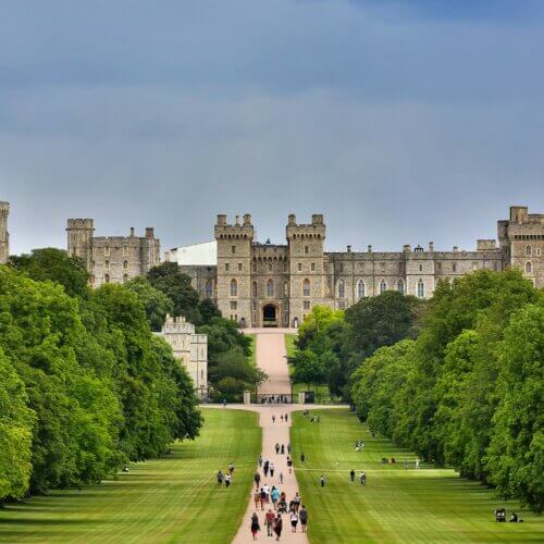 Windsor Castle: people walking on green grass field near brown concrete building during daytime