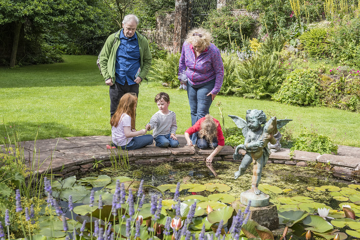 Family exploring the garden at Acorn Bank, Cumbria